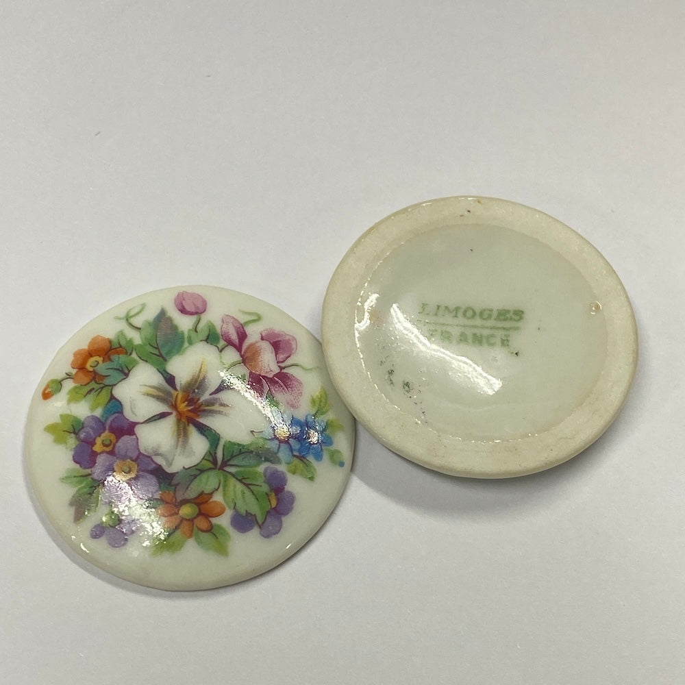 Two ceramic discs with floral designs on a white background