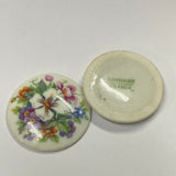 Two ceramic discs with floral designs on a white background
