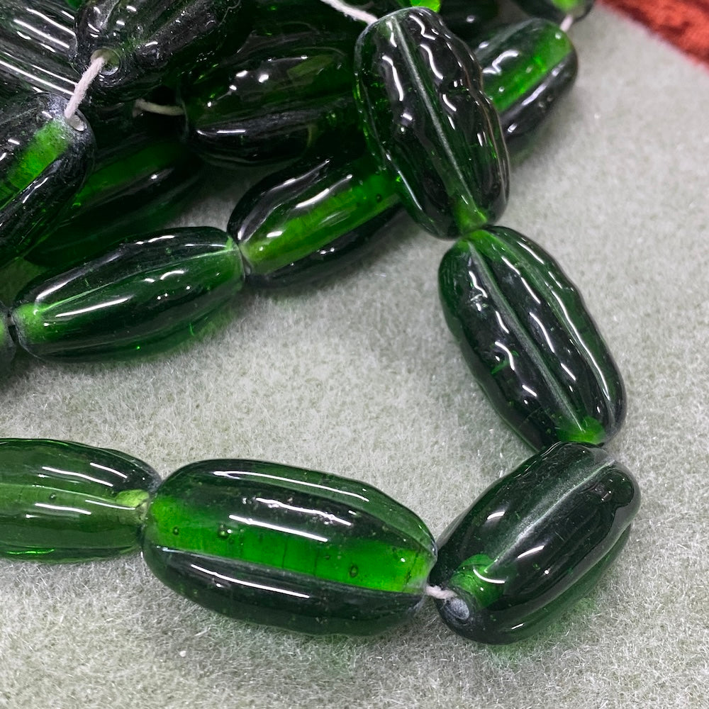 Green glass beads on a textured surface