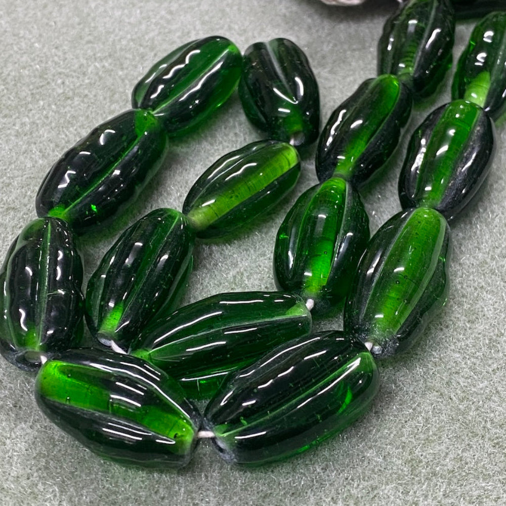 Green glass beads on a gray surface