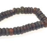 Close-up of dark brown recycled glass beads on a white background