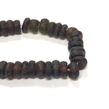 Close-up of dark brown recycled glass beads on a white background