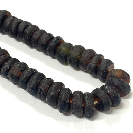 Close-up of dark brown recycled glass beads on a white background