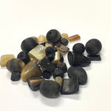 Assorted hand carved natural horn beads on a white background