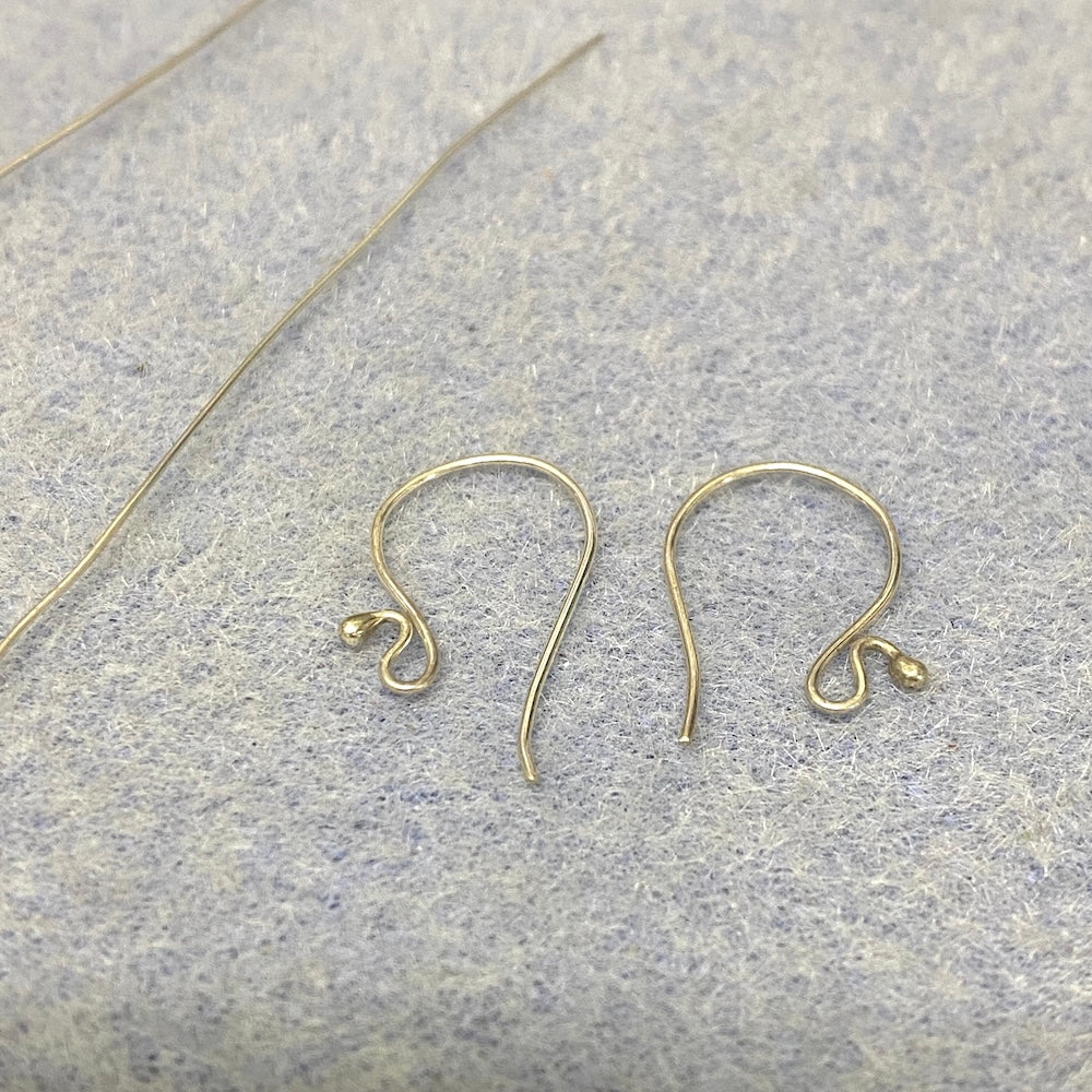 Sterling silver earring hooks on a textured gray surface