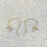 Two sterling silver 925 Bali earring hooks on a textured gray background