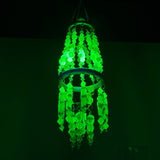 Decorative wind chime with vaseline uranium green and yellow beads hanging indoors under black light