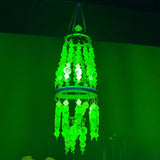 Glowing green chandelier against a dark background