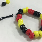 Beaded tribal aboriginal colour bracelet with red, yellow, and black beads on a white background