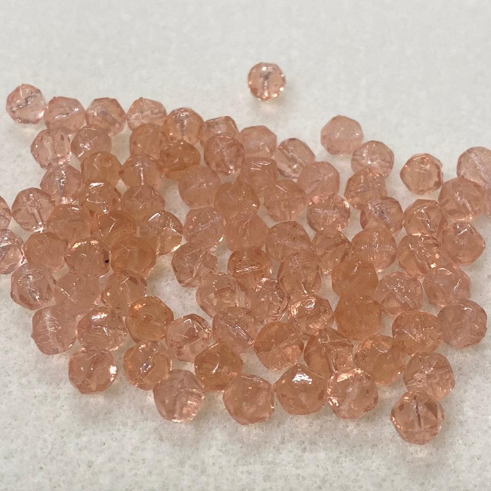 Collection of pinkish-brown glass beads on a light gray background