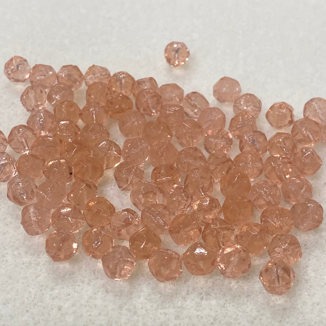 Collection of pinkish-brown glass beads on a light gray background