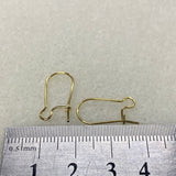 Gold earring hooks on a ruler for size reference