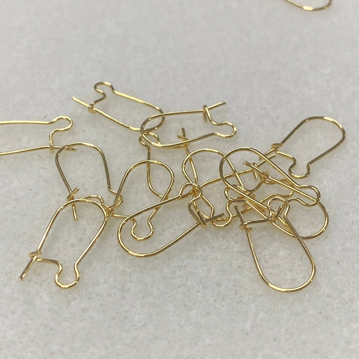 gold metal ear fittings with a closure on the back with a grey background