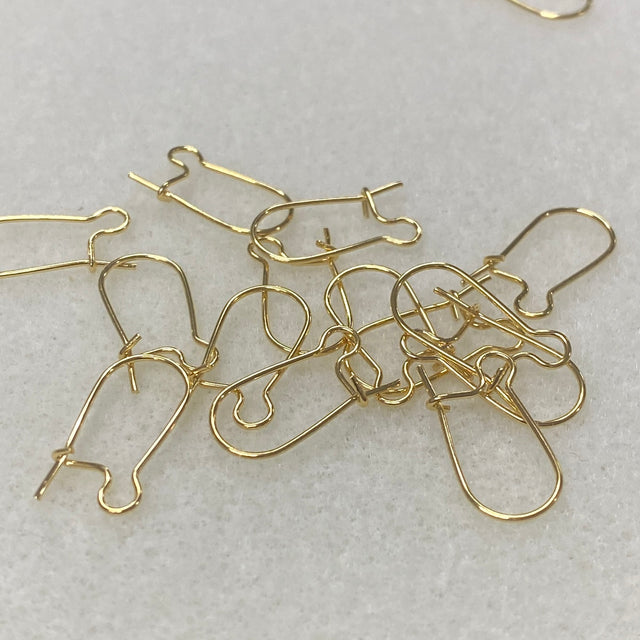 gold metal ear fittings with a closure on the back with a grey background