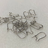 Silver earring hooks on a light gray surface