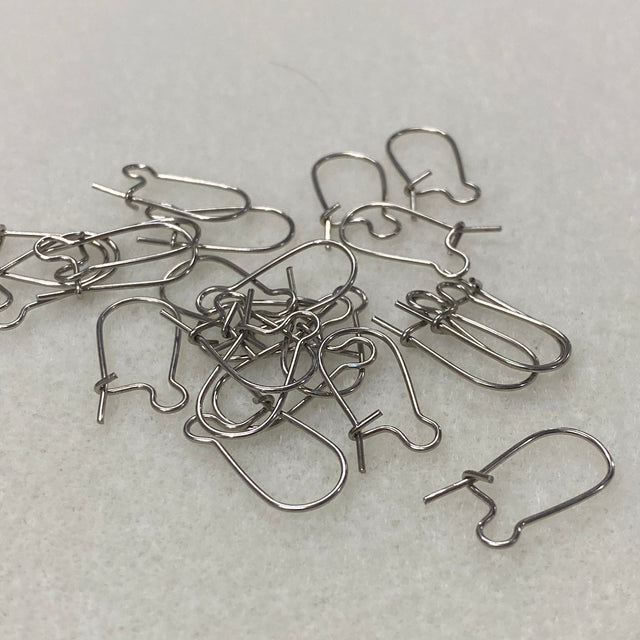 Silver earring hooks on a light gray surface