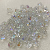 Clear fire polish crystal glass beads with iridescent flash on a light gray background