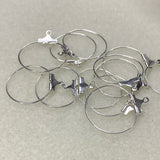 Set of silver hoop earrings on a light gray background