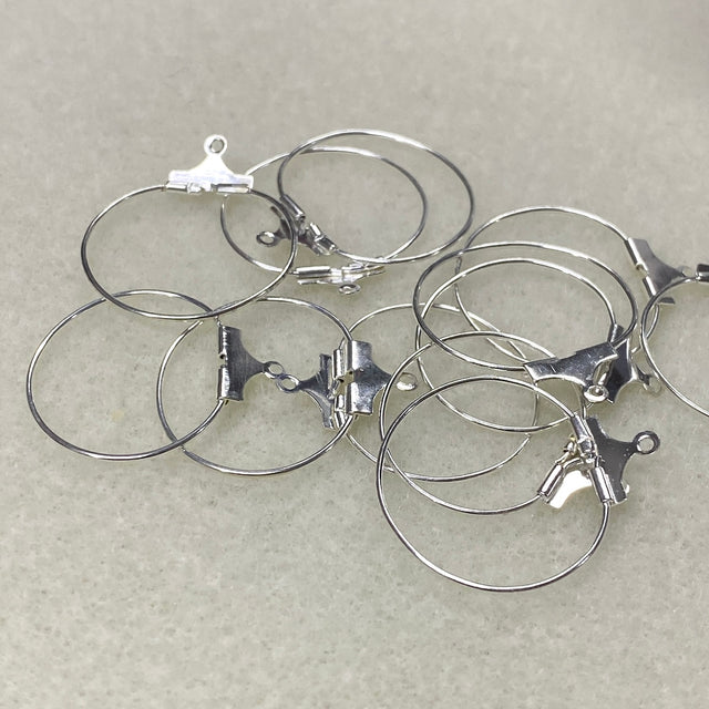 Set of silver hoop earrings on a light gray background