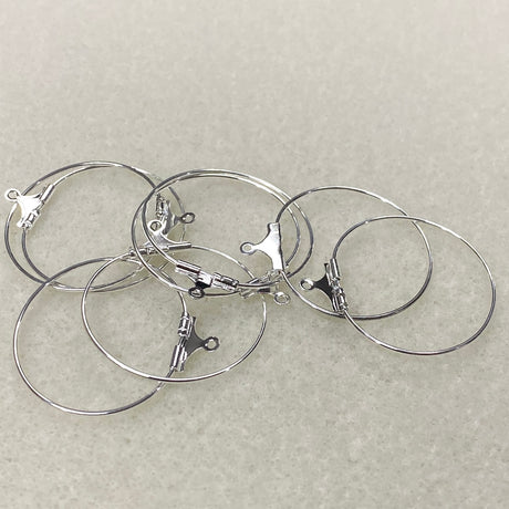 Set of silver hoop earrings on a light gray background