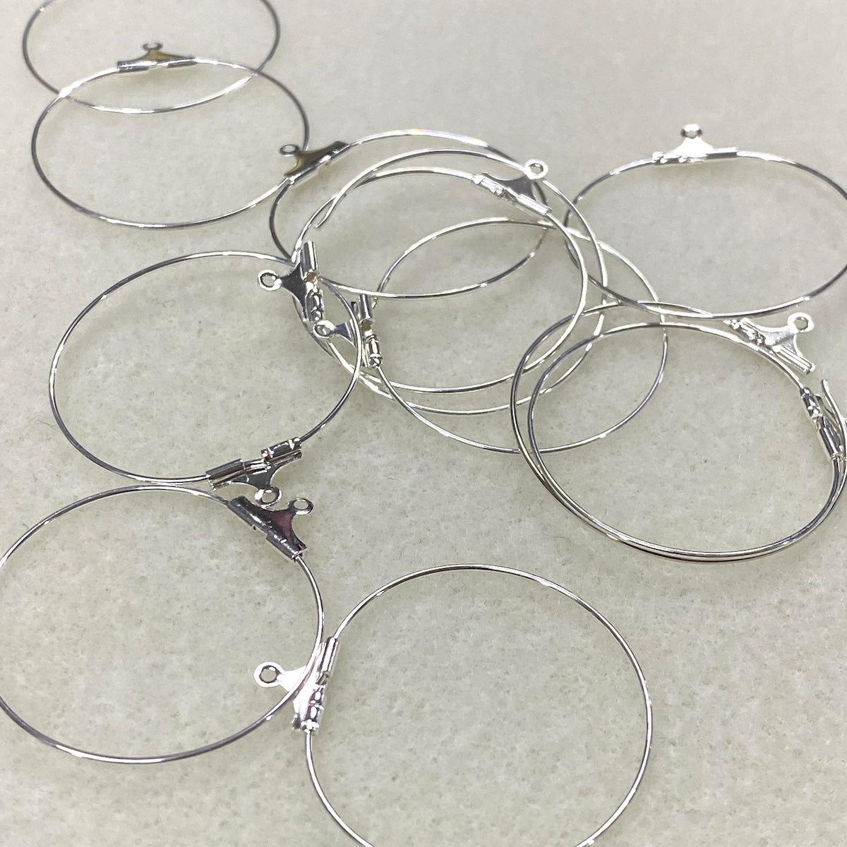 Silver hoop earrings on a light gray background