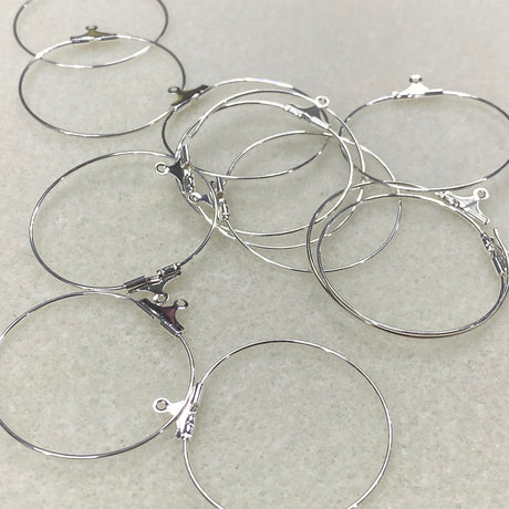 Silver hoop earrings on a light gray background