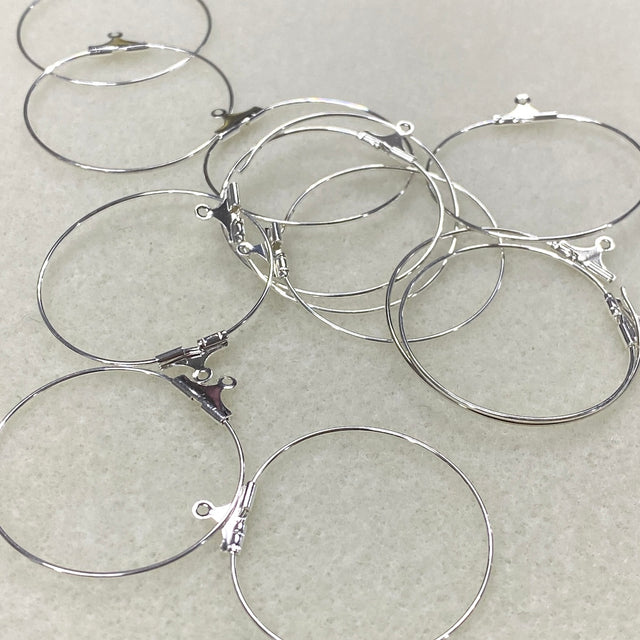 Silver hoop earrings on a light gray background