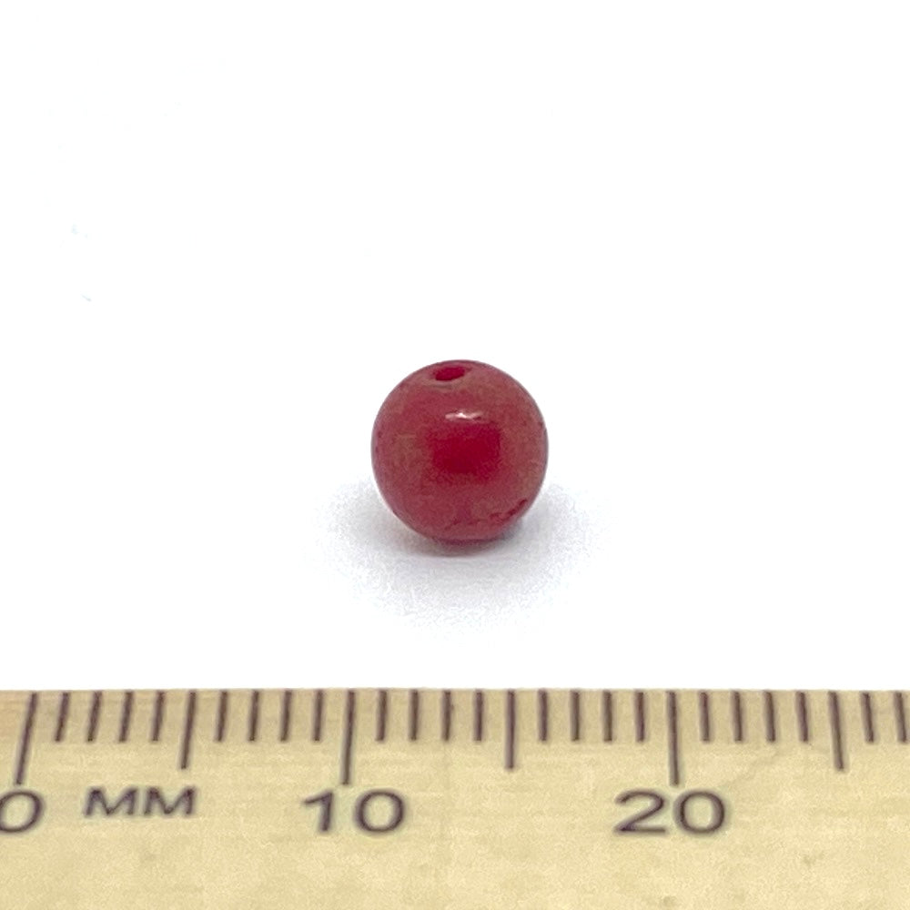 Red bead on a ruler for size reference