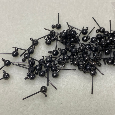 Collection of black jewelry ear stud components on a light gray background