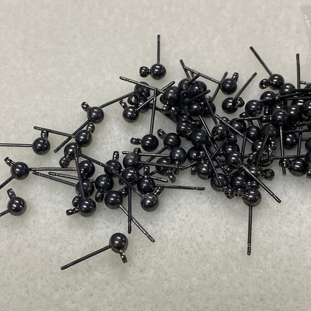 Collection of black jewelry ear stud components on a light gray background