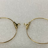 Gold hoop earrings with clasp on a light gray background