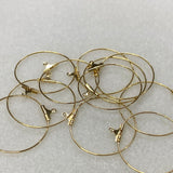 Gold hoop earrings with clasps on a light gray background