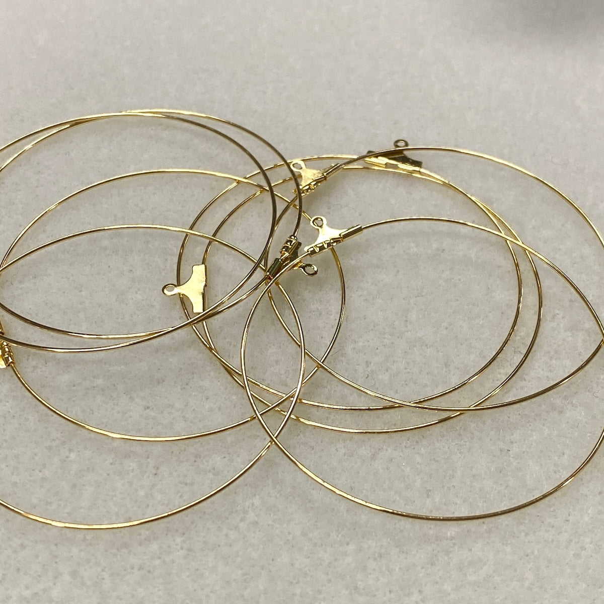 Gold hoop earrings on a light gray background