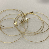 Gold hoop earrings on a light gray background
