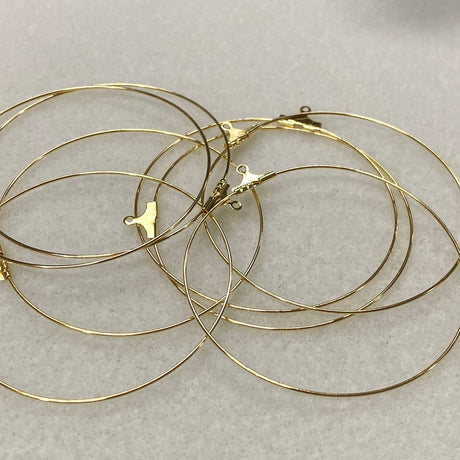 Gold hoop earrings on a light gray background