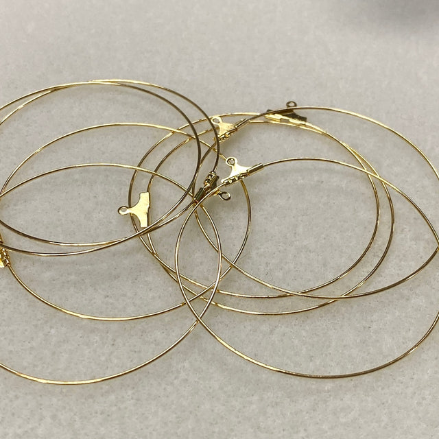Gold hoop earrings on a light gray background
