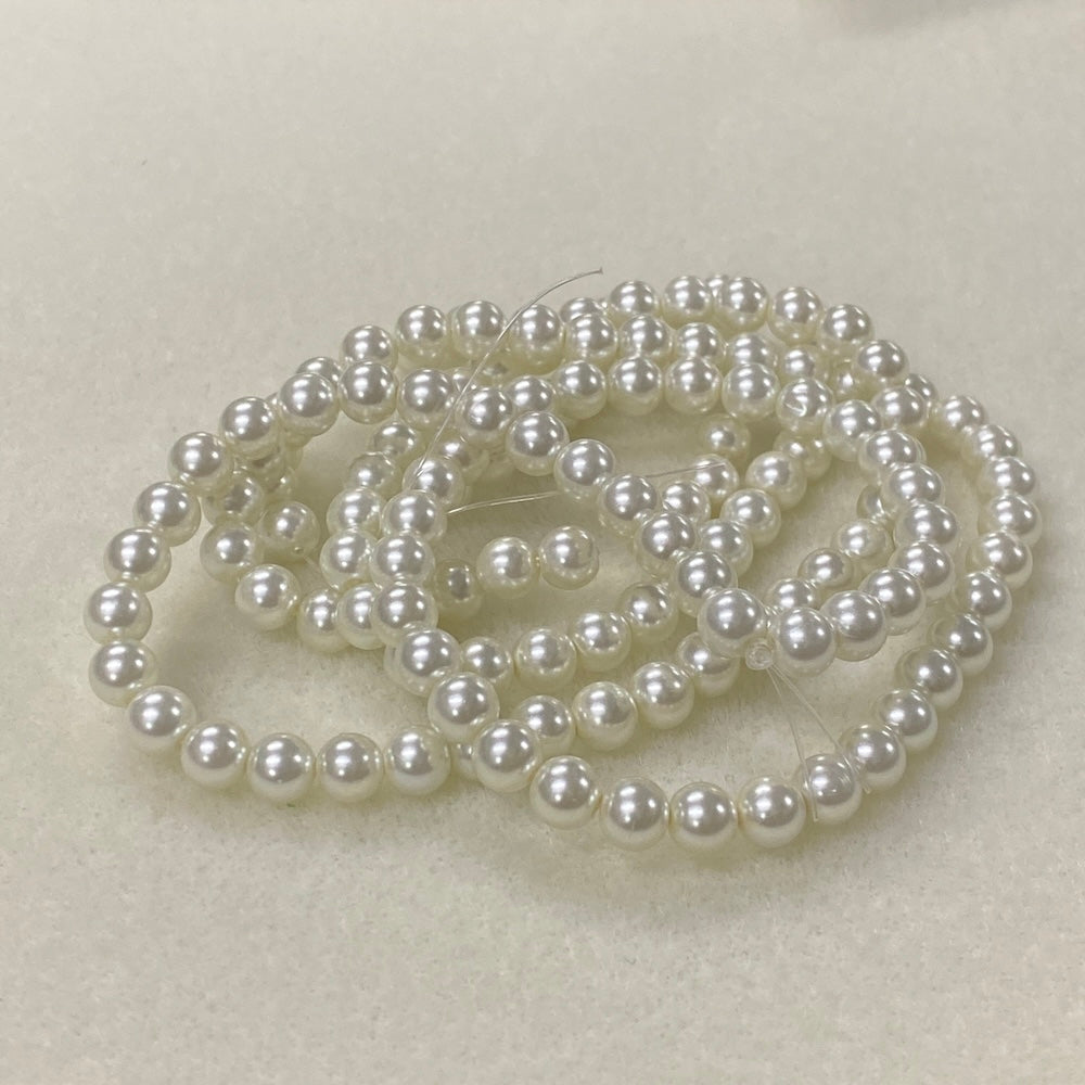 String of white pearls on a light beige background