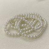 String of white pearls on a light beige background