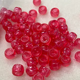 dark rose pink plastic beads on a white background