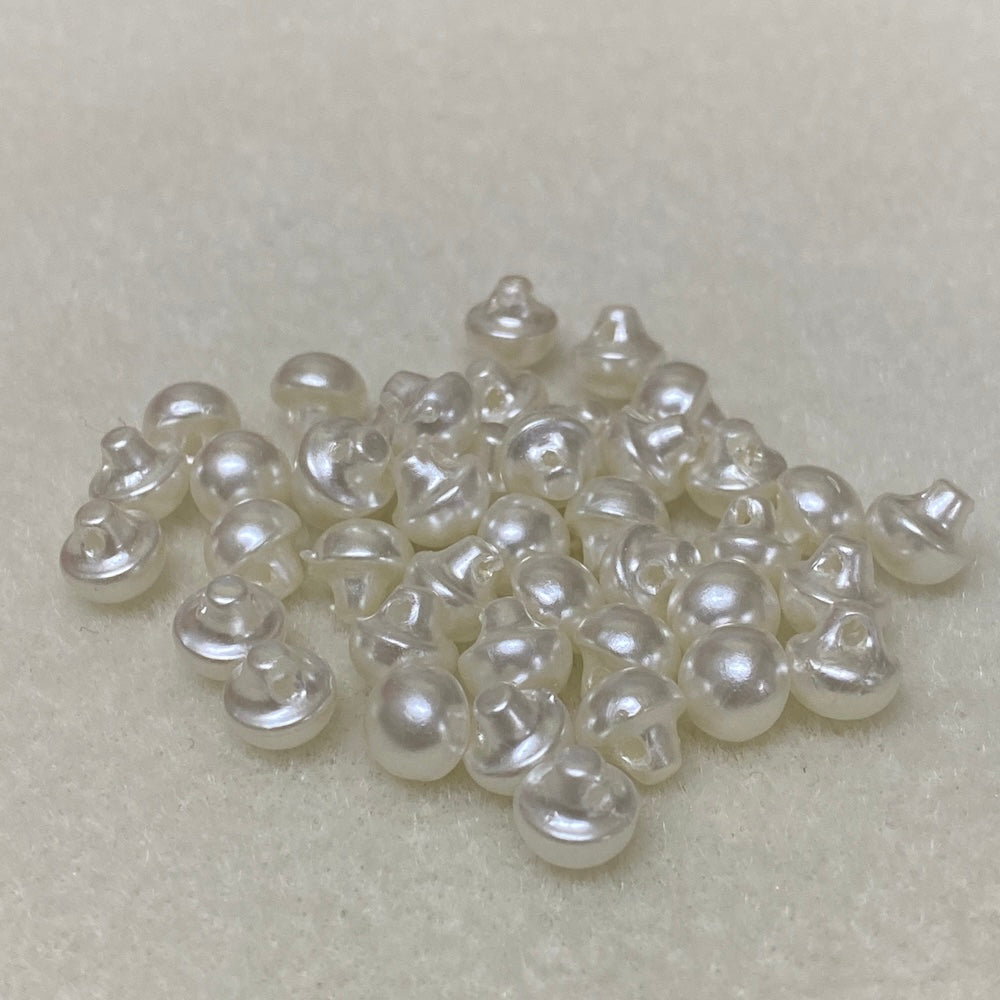 Collection of white pearl buttons on a light gray background