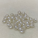 Collection of white pearl buttons on a light gray background
