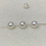 Pearl buttons on a thin metal rod against a light gray background