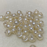 Collection of cream pearl buttons on a light gray background