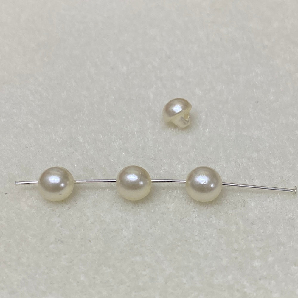 Collection of cream pearl buttons on a light gray background