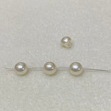Collection of cream pearl buttons on a light gray background