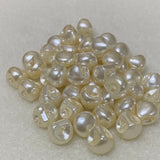 Collection of white pearl buttons on a light gray background