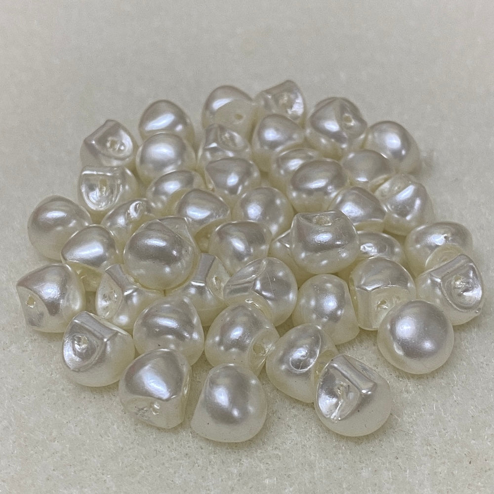 Collection of white pearl buttons on a light gray background
