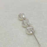 Collection of white pearl buttons on a light gray background