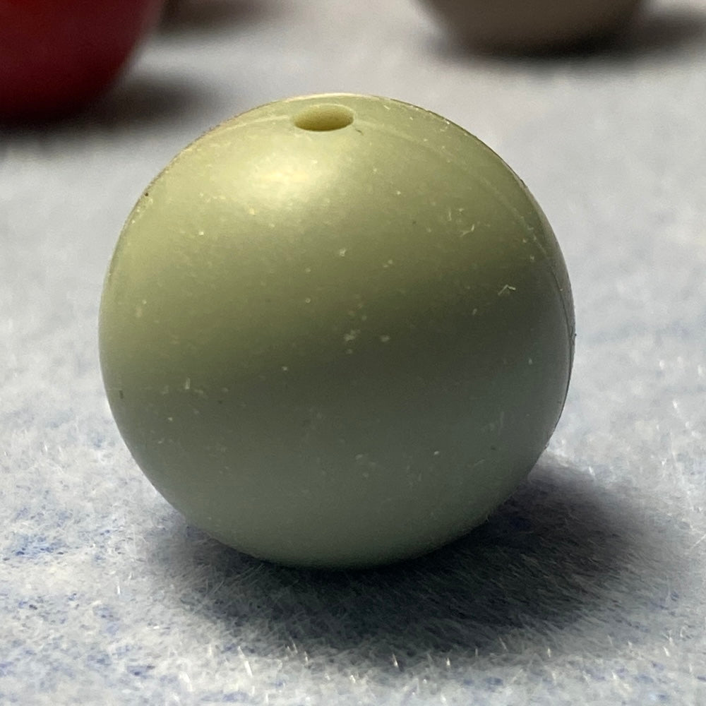 light green silicone bead on a textured gray background