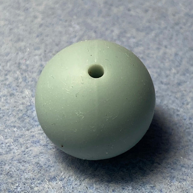 light blue silicone bead on a textured gray background